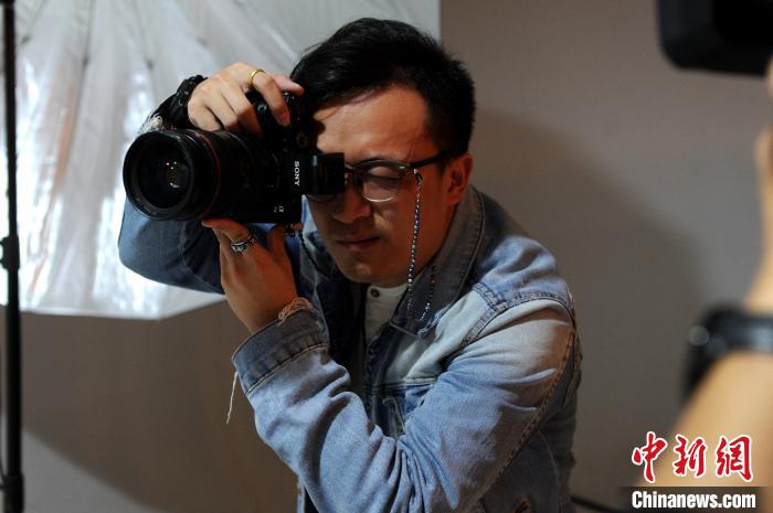 蔡鶴立在他的工作室為客人攝影。　張金川 攝