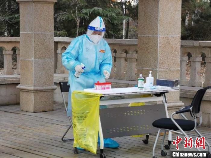 圖為醫(yī)務(wù)工作者在核酸檢測(cè)前進(jìn)行消毒工作?！∏谌A 攝