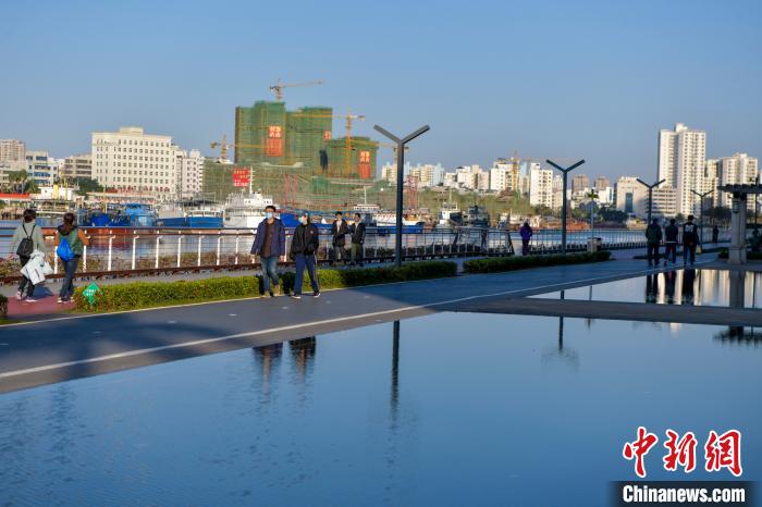 圖為市民在海口灣散步?！●樤骑w 攝