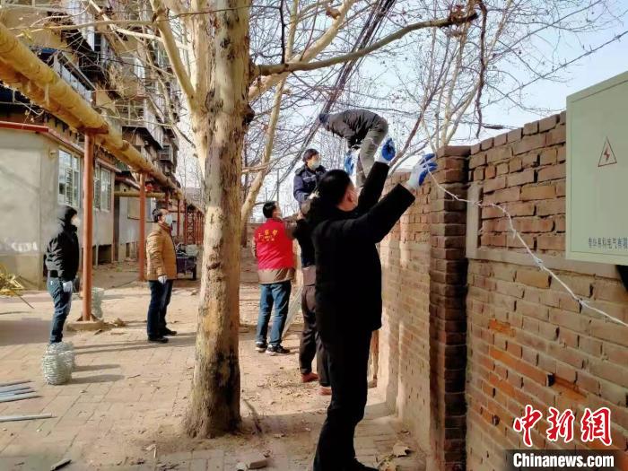 圖為小區(qū)志愿者為小區(qū)圍墻加裝倒刺鐵網(wǎng)?！〈迺?攝