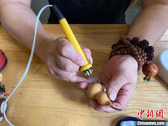 陶思俊正在進(jìn)行葫蘆烙畫創(chuàng)作?！￡愳o 攝