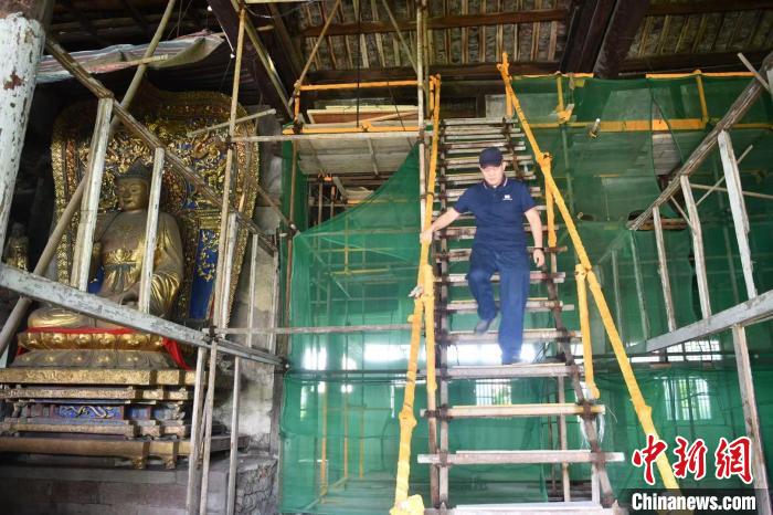 目前李曉洋正在成都青白江區(qū)明教寺覺皇殿修復壁畫。　張浪 攝