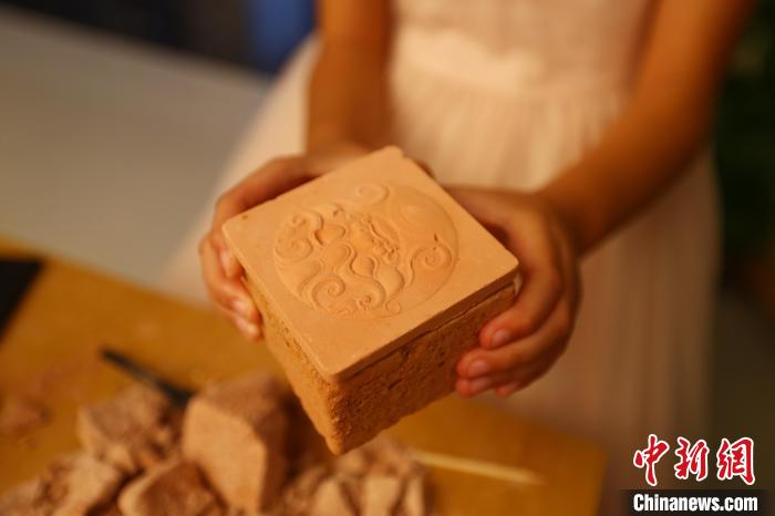 圖為江西省博物館天工坊，一名游客準備打開“考古盲盒”文創(chuàng)產(chǎn)品?！⒄祭?攝