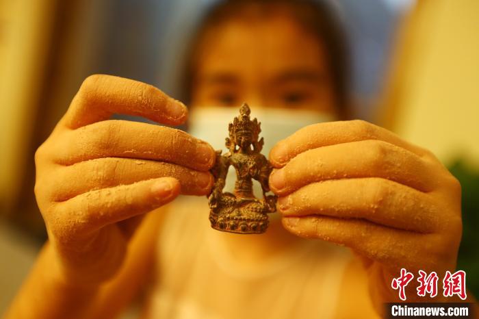 圖為一位女孩從“考古盲盒”中挖出的一件“微縮文物”?！⒄祭?攝