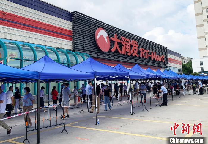 民眾排著長(zhǎng)長(zhǎng)的隊(duì)伍，在工作人員的指引下，等待進(jìn)入超市購(gòu)物。　崔佳明 攝