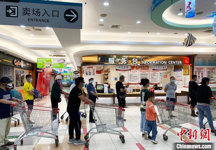 民眾戴著口罩，有序排隊(duì)，等待進(jìn)入超市購(gòu)物?！〈藜衙?攝