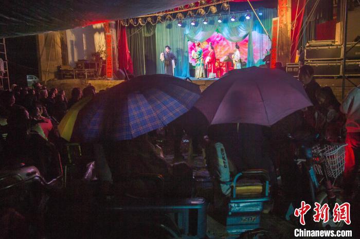 民眾在雨中觀看蒲劇?！∥淇〗?攝