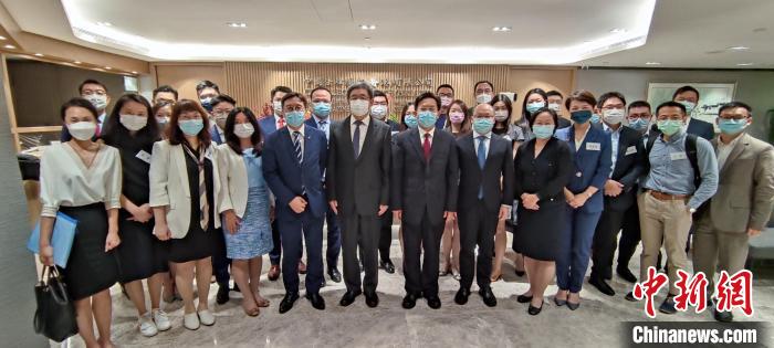 香港中聯(lián)辦秘書長王松苗一行與“港漂”律師們合影?！∠愀壑新?lián)辦供圖