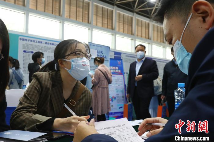 圖為南昌大學前湖校區(qū)校園招聘活動現(xiàn)場，一名大學生正在求職現(xiàn)場填寫報名表?！⒄祭?攝
