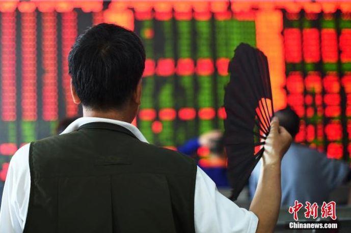 資料圖：股民一邊搖扇一邊關(guān)注股市大盤。&nbsp;<a target='_blank' href='/'>中新社</a>發(fā) 武俊杰 攝