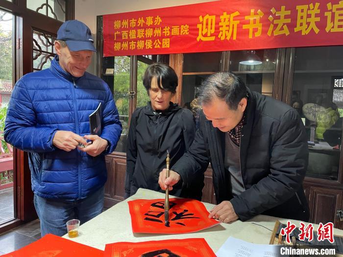 柳州市一書法家教兩位英國人書寫春聯(lián)?！×周?攝
