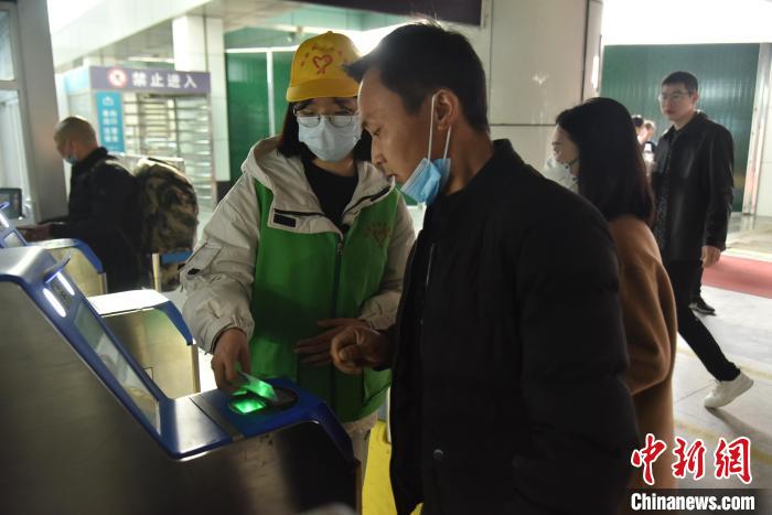 圖為志愿者協(xié)助乘客?！№n毅 攝