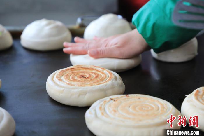 “火燒”師傅把半成品放在鐵板上旋磨成型后壓平?！∴囆?攝