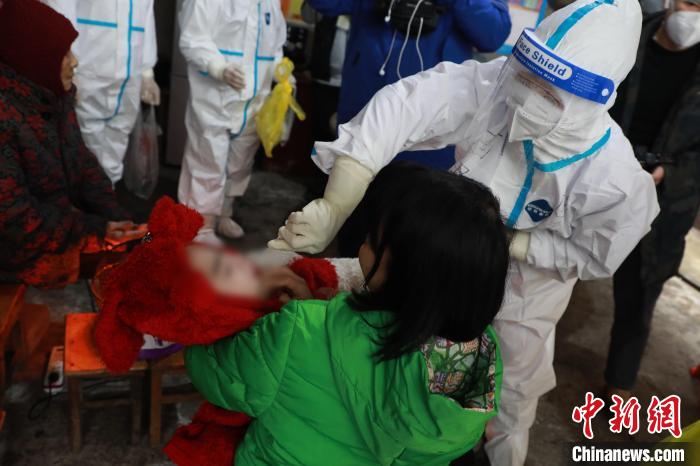 圖為歐秋潔為一名兒童做核酸采樣?！￡惽锵?攝