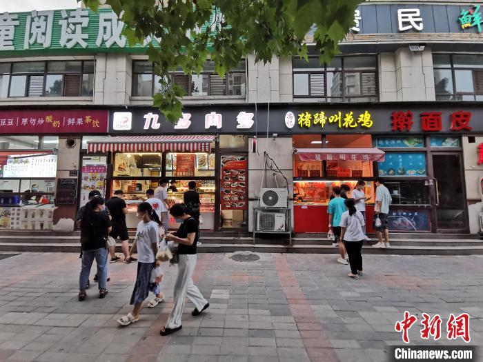 資料圖：市民在街邊小店購(gòu)買(mǎi)小吃。 韓章云 攝