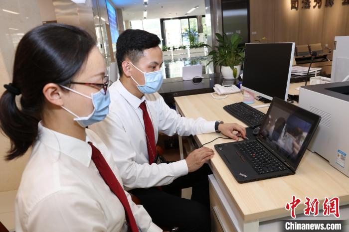 工作人員引導(dǎo)香港當(dāng)事人進(jìn)行身份認(rèn)證?！∩蚓К?攝