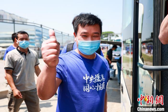 建設者們身穿文化衫，帶著燦爛的笑容離開駐地?！≠Z凱 攝