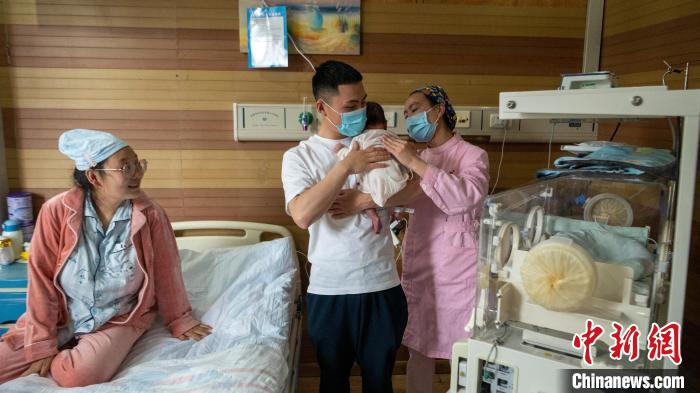 新生兒家庭化病房內(nèi)，護(hù)士指導(dǎo)新手爸爸?！⒅铱?攝