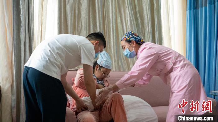 新生兒家庭化病房內(nèi)，護(hù)士指導(dǎo)新手媽媽喂養(yǎng)?！⒅铱?攝