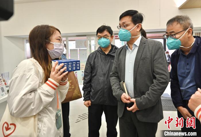 內(nèi)地疫情防控專家到訪深水埗地區(qū)康健中心。中心職員向?qū)＜医榻B向長者免費派發(fā)快速抗原測試套裝的工作。　香港特區(qū)政府新聞處供圖