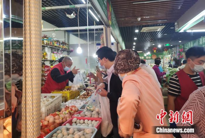 北京豐臺區(qū)某菜市場內(nèi)，不少人在購買雞蛋。 中新財經(jīng)記者 謝藝觀 攝