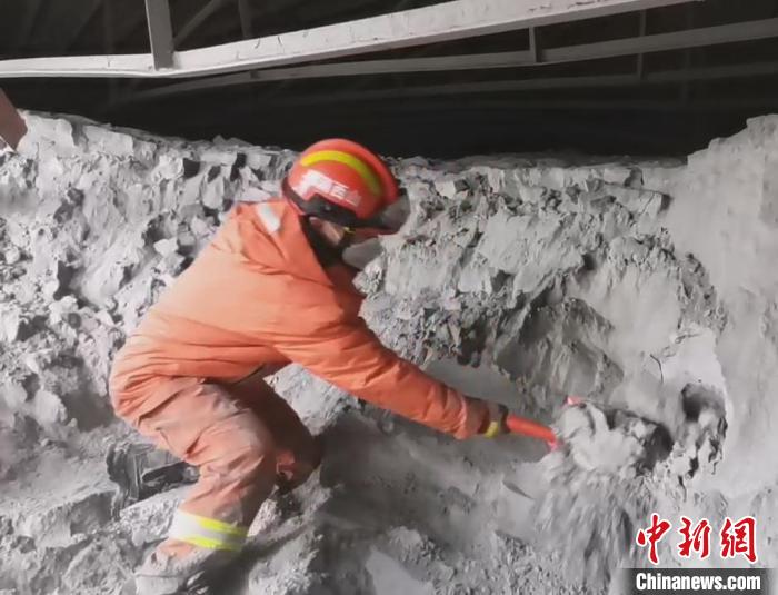 一名消防員單腿跪在粉煤灰堆上搜救被困人員?！↓R帥 攝