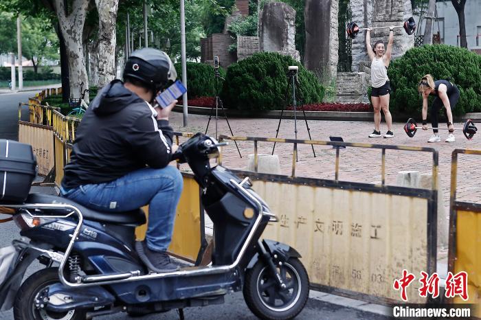 市民在防范區(qū)街頭空曠的場地上鍛煉，路過的快遞員停車觀看?！∫罅⑶?攝