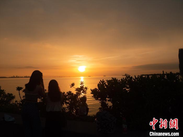觀賞落日美景的游客?！×栝?攝