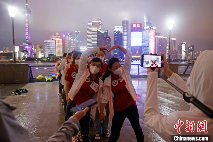 華中科技大學(xué)同濟(jì)醫(yī)學(xué)院附屬同濟(jì)醫(yī)院援滬醫(yī)療隊(duì)隊(duì)員冒雨在外灘濱江步道上擺造型合影?！∫罅⑶?攝