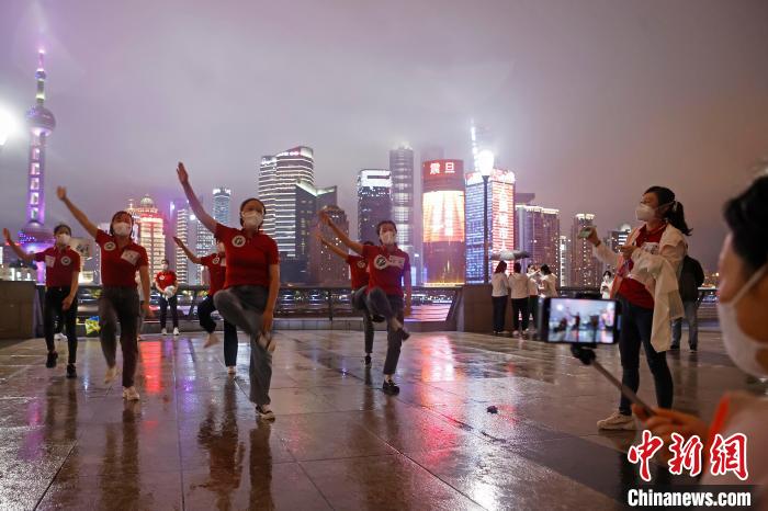 華中科技大學(xué)同濟(jì)醫(yī)學(xué)院附屬同濟(jì)醫(yī)院援滬醫(yī)療隊(duì)隊(duì)員冒雨在外灘濱江步道上擺造型合影?！∫罅⑶?攝