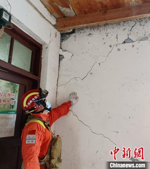 森林消防員現(xiàn)場查看開裂的墻體。　曾鵬 攝