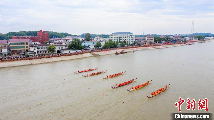 圖為無人機(jī)航拍參賽的龍舟隊(duì)伍在開闊的贛江上奮勇爭(zhēng)先，岸邊擠滿了前來觀賽的民眾?！∏裾?攝