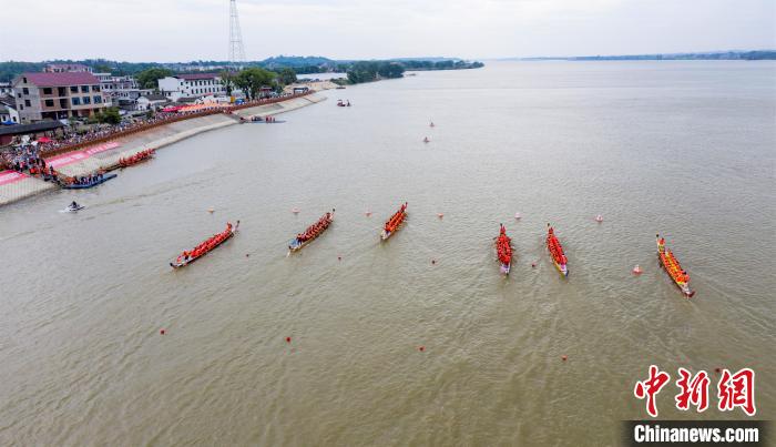 圖為參賽的龍舟隊(duì)伍在贛江之上劈波斬浪，奮力向前，岸邊擠滿了前來觀賽的民眾?！∏裾?攝