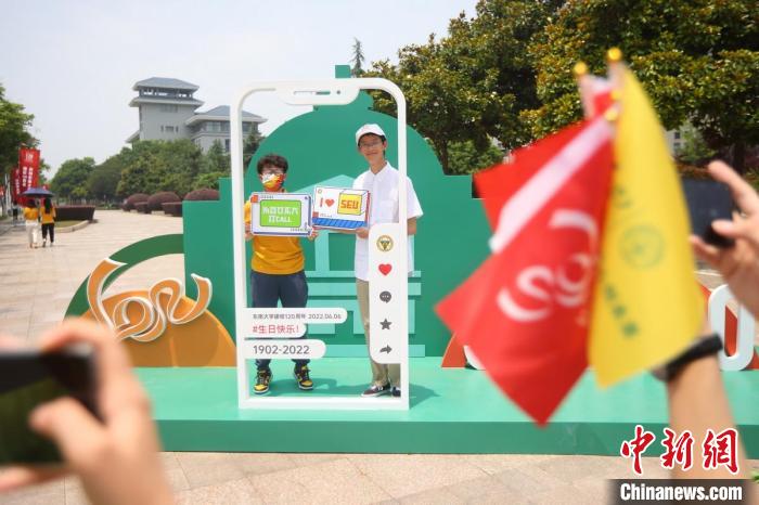 大學生在校園內(nèi)拍攝校慶主題照片?！°蟛?攝