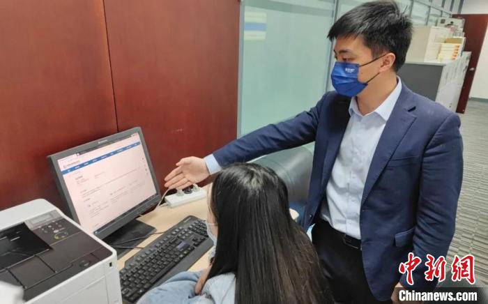 圖為廈門銀行員工指導(dǎo)臺商通過金服云平臺申請“臺企快服貸”。　鐘欣 攝