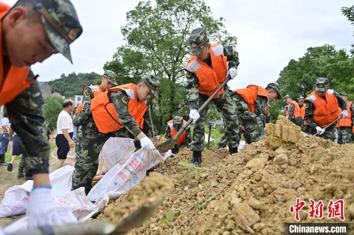 武警江西總隊機(jī)動支隊官兵奔赴江西景德鎮(zhèn)市樂平市開展搶險救援，填裝沙袋?！∨矶?攝