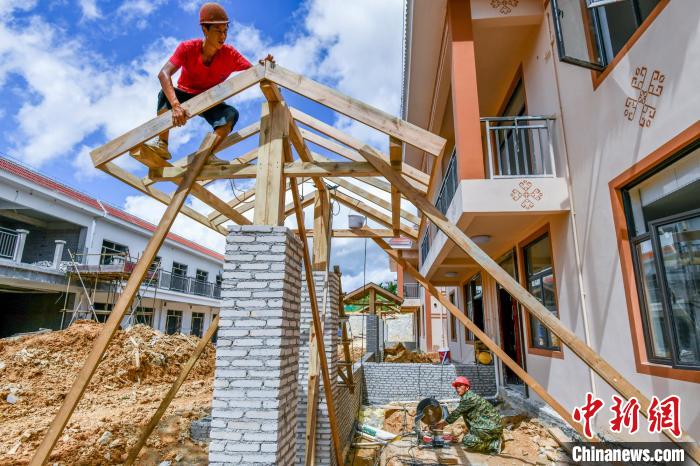 圖為海南省保亭黎族苗族自治縣什玲鎮(zhèn)(水賢村、什東村)生態(tài)搬遷安置區(qū)項(xiàng)目施工現(xiàn)場(chǎng)，工人安裝入戶門(mén)樓?！●樤骑w 攝