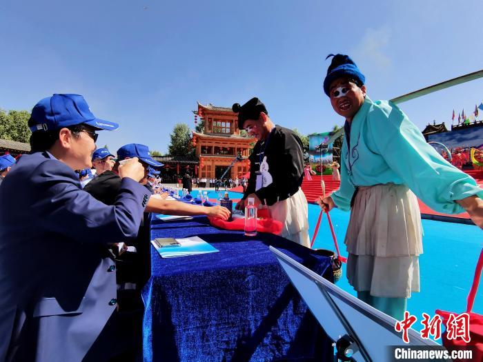 圖為前來參加開幕式的觀眾品嘗青稞酒?！∑钤鲚?攝