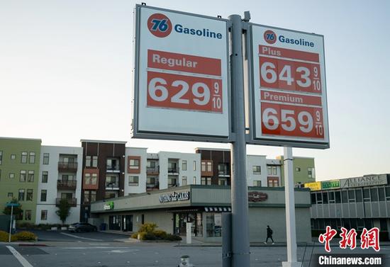 當(dāng)?shù)貢r間5月16日，行人從美國加州圣馬特奧縣一家加油站油價牌附近經(jīng)過。美國汽車協(xié)會的全國平均汽油價格監(jiān)測報告顯示，美國全國普通汽油平均價格當(dāng)日升至每加侖4.48美元，創(chuàng)歷史新高。 <a target='_blank' href='/'>中新社</a>記者 劉關(guān)關(guān) 攝