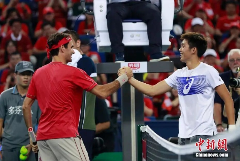 資料圖：網(wǎng)球名將費德勒與中國球員華潤豪握手致意。湯彥俊 攝