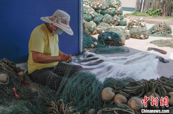 河北省唐山市豐南區(qū)黑沿子鎮(zhèn)漁民高貴娟正在補(bǔ)網(wǎng)?！￡愜?攝