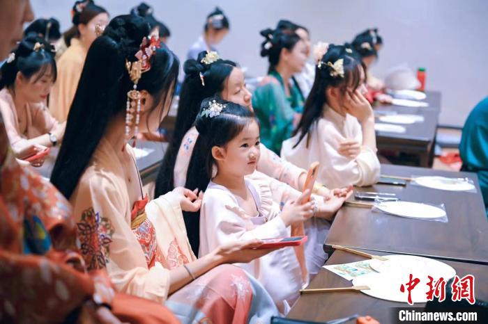 圖為游客在“宮宴”體驗傳統(tǒng)文化?！m宴供圖