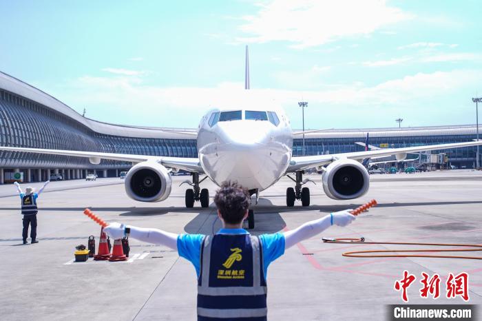 圖為機(jī)務(wù)人員引導(dǎo)飛機(jī)?？俊！￡惞谘?攝