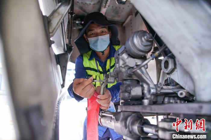 圖為放行工程師在飛機(jī)前起落架插上轉(zhuǎn)彎銷?！￡惞谘?攝