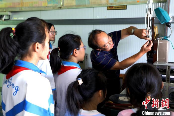 圖為肖光合向參觀的學生演示老式放映機的使用?！∩筹w 攝