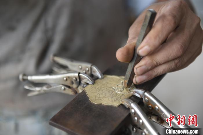 王二兵在手柄上精心鏨花。　高占峰 攝