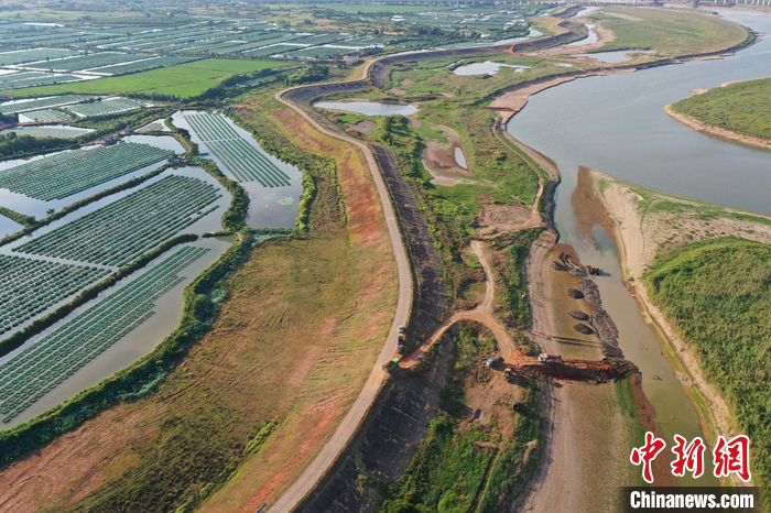 圖為8月23日，在鄱陽(yáng)湖畔的江西省南昌市進(jìn)賢縣三里鄉(xiāng)六零圩，圩堤左側(cè)是農(nóng)戶的黃鱔養(yǎng)殖基地，右側(cè)是正在挖渠蓄水的挖掘機(jī)。（無(wú)人機(jī)照片） <a target='_blank' href='/'>中新社</a>記者 劉占昆 攝