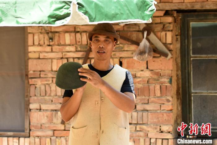 清水毛氈制作技藝傳承人苑國(guó)勝展示制作的氈帽和氈坎肩。　高丹鈺 攝