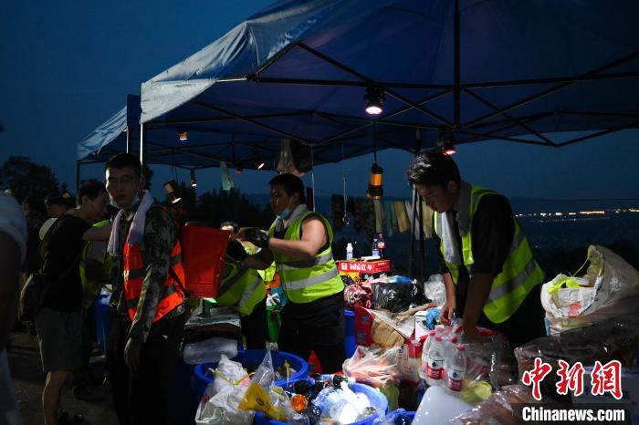 圖為志愿者們分發(fā)物資?！『闻罾?攝