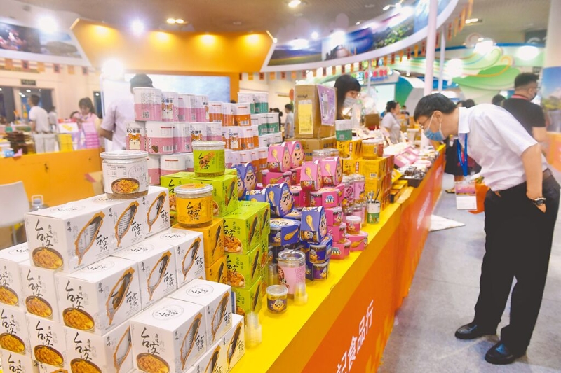 海關總署1日突然公告，臺灣未完成生產企業(yè)注冊更新的食品業(yè)者“暫停進口”。圖為廈門2021海峽旅游博覽會，臺灣食品展區(qū)吸引參觀者。（中新社）.jpg